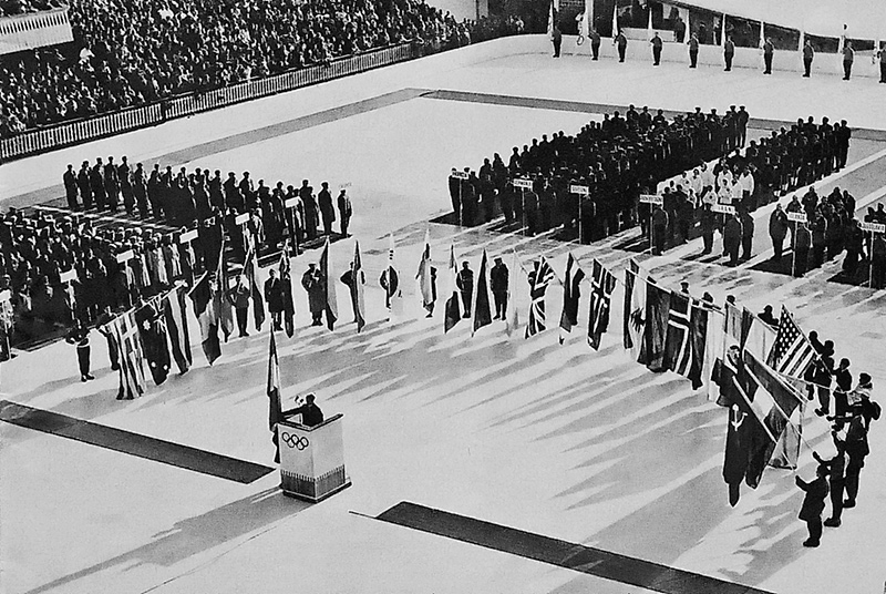 25 января жители Кортина д’Ампеццо, многочисленные туристы и 32 национальные команды пришли на «Ледяной стадион». Здесь состоялось торжественное открытие Олимпийских игр 1956 года. На фото запечатлен один из самых значимых моментов каждой Олимпиады: спортсмены произносят слова олимпийской клятвы. 