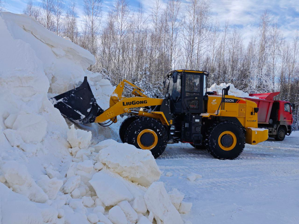 С помощью погрузчиков и самосвалов снег из куч доставлялся непосредственно на трассу. 