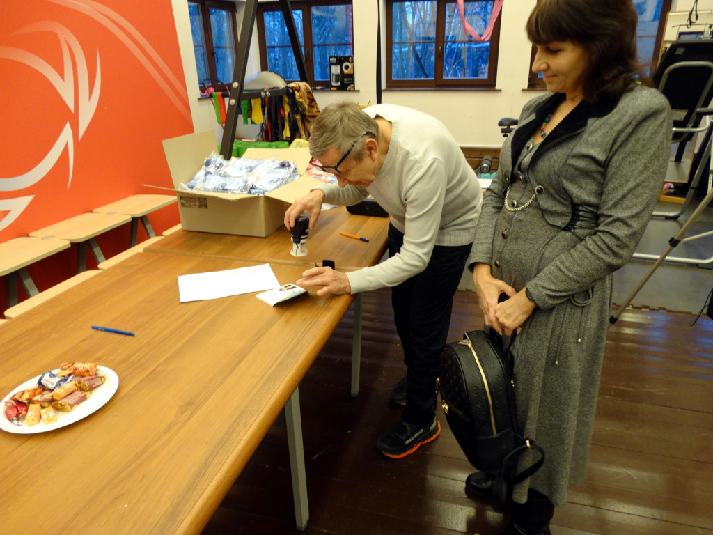 Президент Союза марафонов "Лыжная Россия" Сергей Емельянов ставит печать в паспорт Оксаны Нестерец, специально приехавшей на награждение СМЛР из Иркутска. 